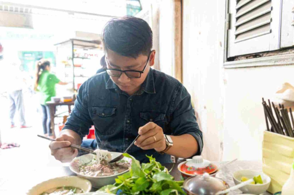 Tourist enjoying Vietnamese Pho